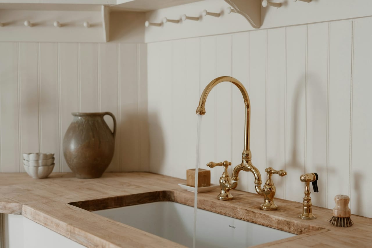 Brass faucet running into a sink